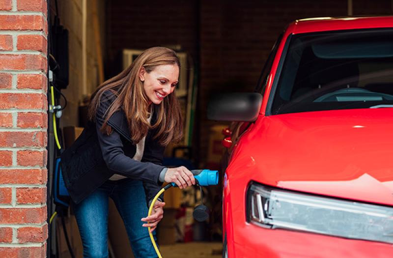 Driver plugging in an electric car at home